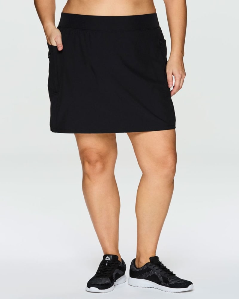 Front of a model wearing a size 1X Prime Perfect Weekend Skort in Black by RBX Active. | dia_product_style_image_id:352926
